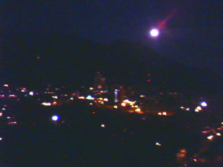 Una luna plena va descubrindose sobre la silueta del Avila... cae la noche